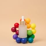 A glass white bottle with a dropper on a beige background, a container for cosmetic products
