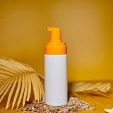 Sunscreen tube mockup with shells, sand yellow background, summer vacations and spf uv-protecting skin care concept, hard light.